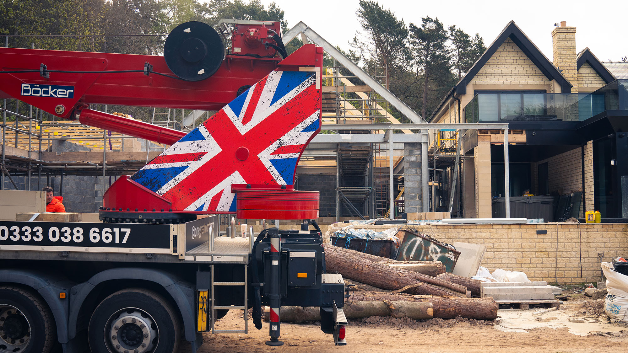 Crane lifting hot tub over a residential garden